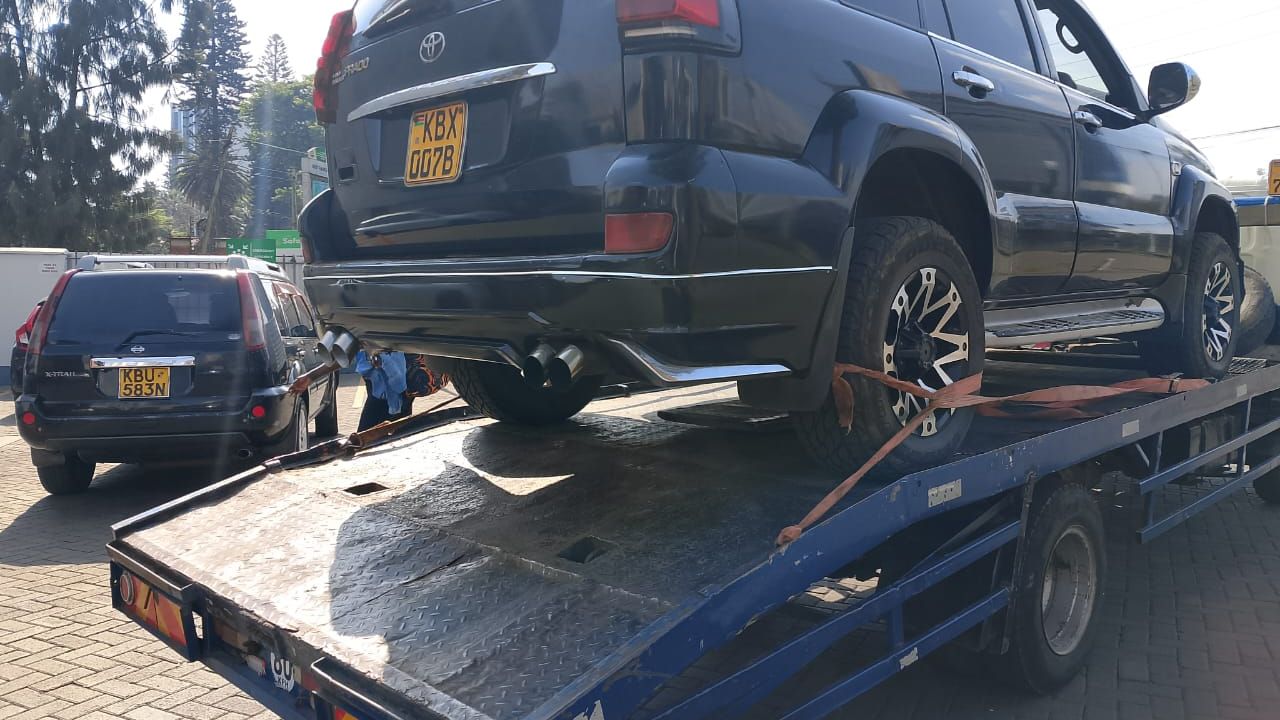 Flatbed tow truck safely transporting a vehicle on highway